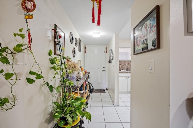 hall featuring sink and light tile patterned flooring