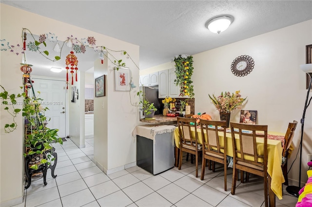 dining space with light tile patterned floors and a textured ceiling