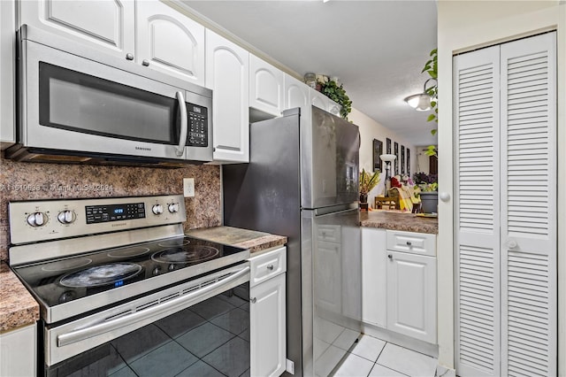 kitchen featuring light tile patterned floors, tasteful backsplash, a textured ceiling, white cabinets, and appliances with stainless steel finishes