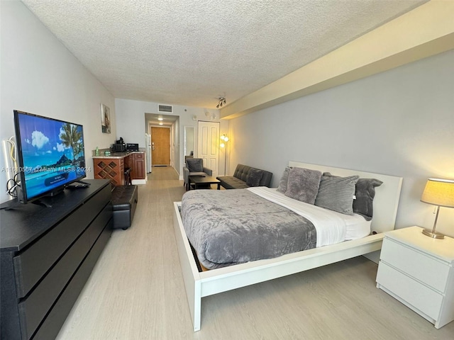 bedroom featuring hardwood / wood-style floors and a textured ceiling