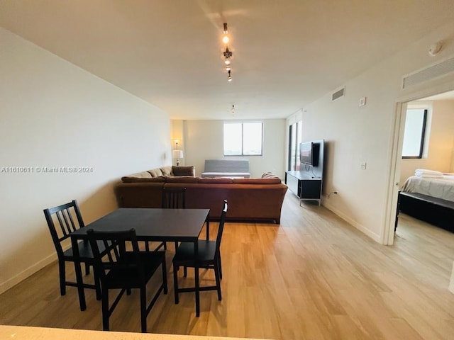 dining space with track lighting and light hardwood / wood-style floors