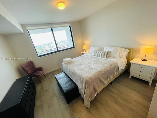 bedroom featuring vaulted ceiling and wood-type flooring