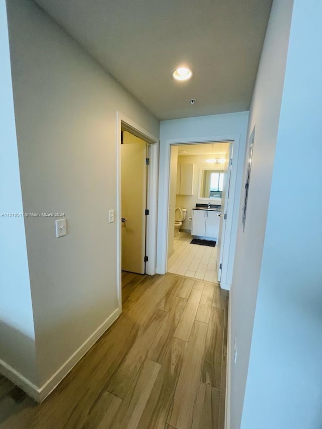 hallway with light hardwood / wood-style floors