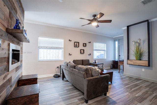 living room with ceiling fan, ornamental molding, and light hardwood / wood-style flooring