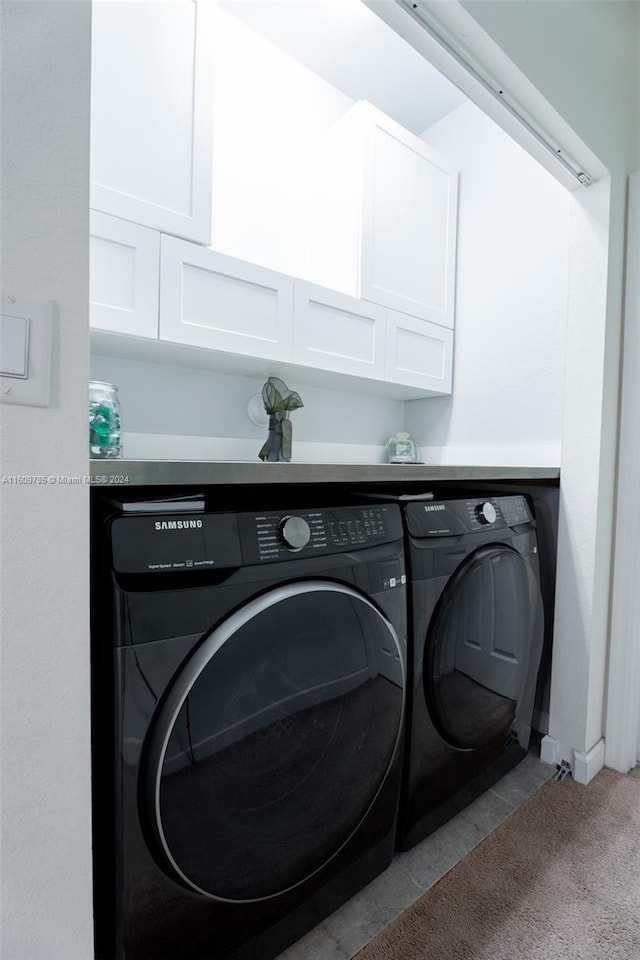 laundry room with cabinets, washer and clothes dryer, and light carpet