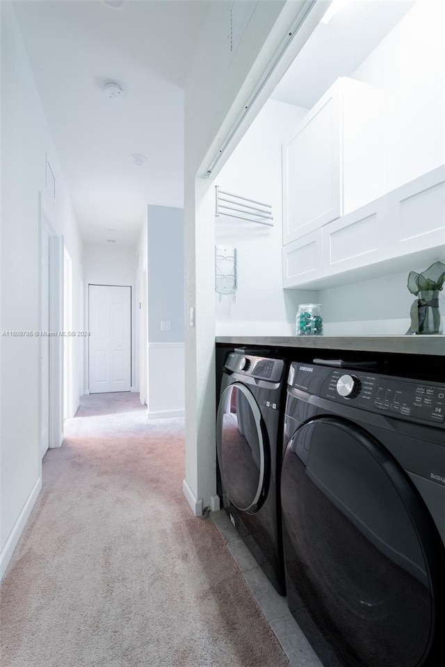 laundry area with cabinets, separate washer and dryer, and light carpet