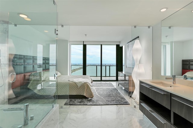 bedroom with access to outside, sink, and a water view