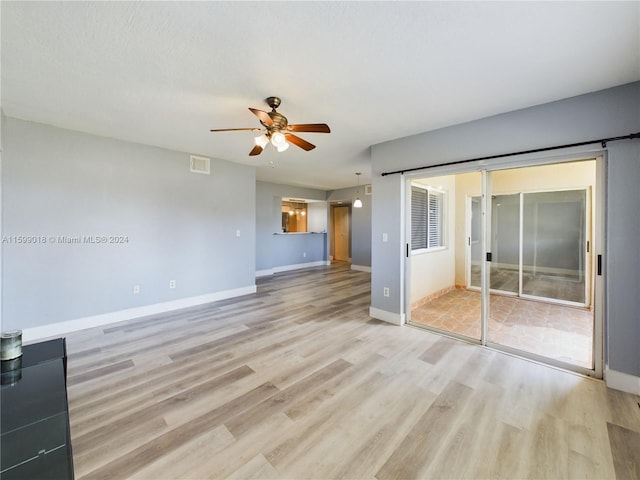 unfurnished living room featuring ceiling fan and light wood-type flooring