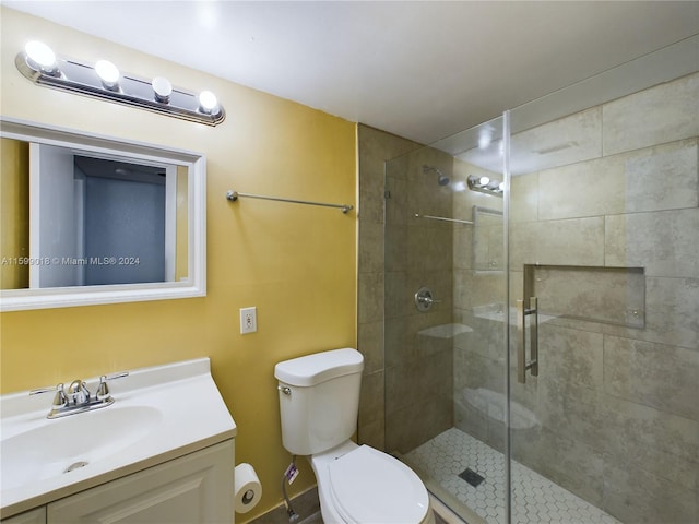 bathroom with vanity, toilet, and a shower with shower door