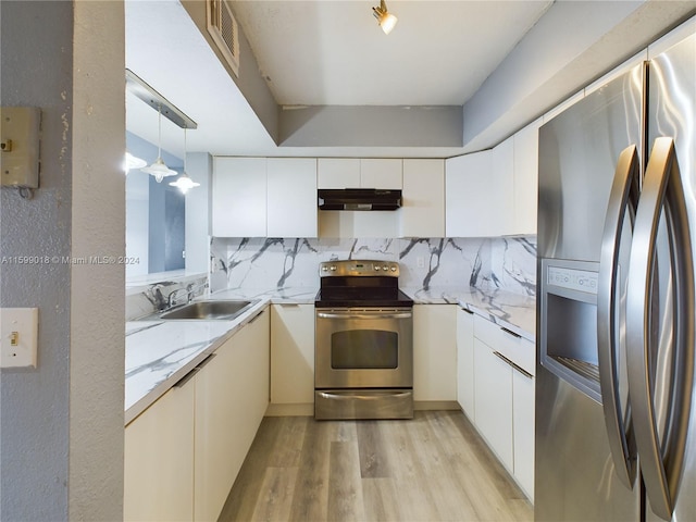 kitchen featuring appliances with stainless steel finishes, sink, light hardwood / wood-style flooring, white cabinets, and hanging light fixtures