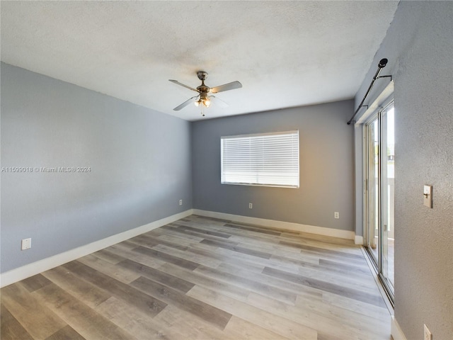 unfurnished room featuring ceiling fan, plenty of natural light, light hardwood / wood-style floors, and a textured ceiling