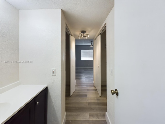 hall featuring dark hardwood / wood-style flooring and a textured ceiling