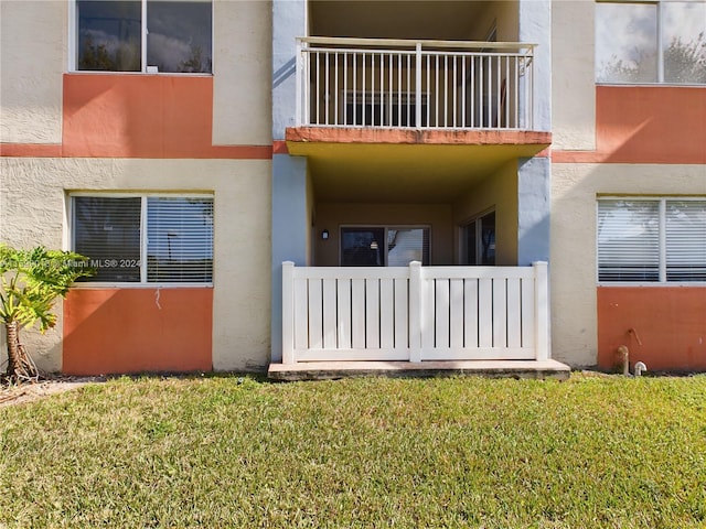 view of exterior entry with a balcony