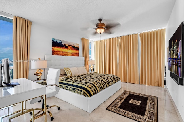 bedroom featuring a textured ceiling, ceiling fan, and light tile patterned flooring