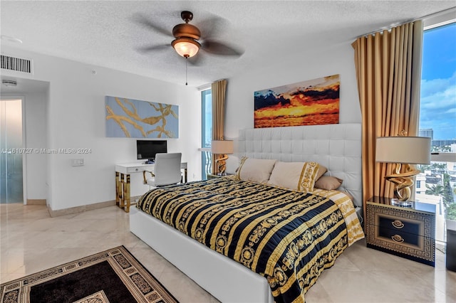 bedroom with ceiling fan and a textured ceiling