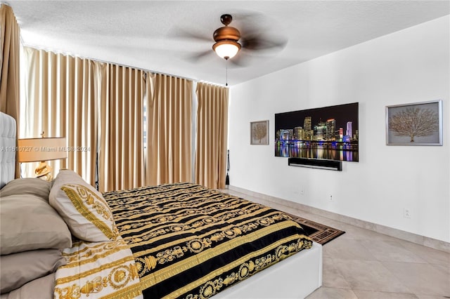 bedroom with ceiling fan and a textured ceiling