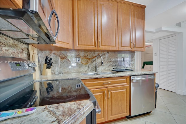 kitchen featuring dishwasher, stove, tasteful backsplash, light stone countertops, and light tile floors