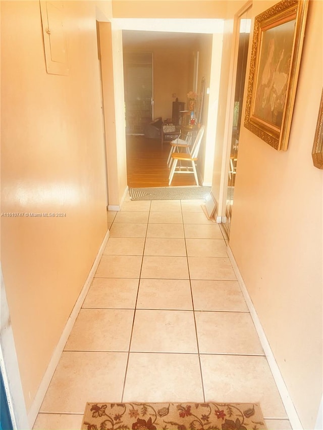 corridor with light tile patterned floors and electric panel