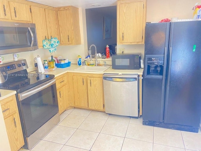 kitchen featuring sink, light tile patterned floors, black appliances, and light brown cabinets