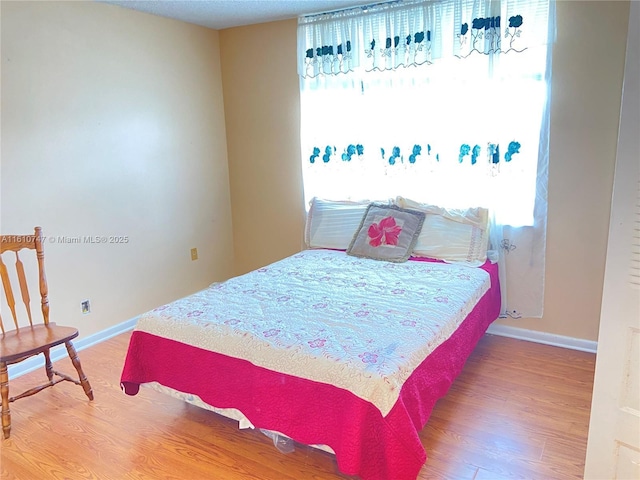 bedroom with baseboards and wood finished floors