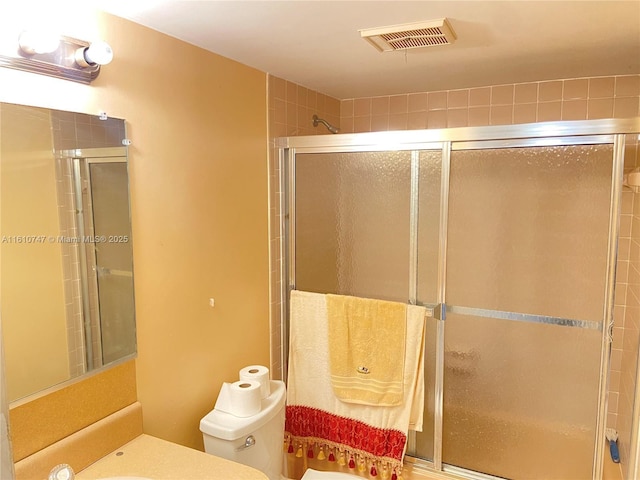 full bath featuring toilet, a stall shower, visible vents, and vanity