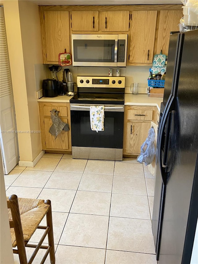 kitchen featuring light tile patterned floors, appliances with stainless steel finishes, light countertops, and brown cabinetry