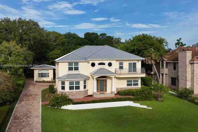 view of front of house with a front lawn and a balcony