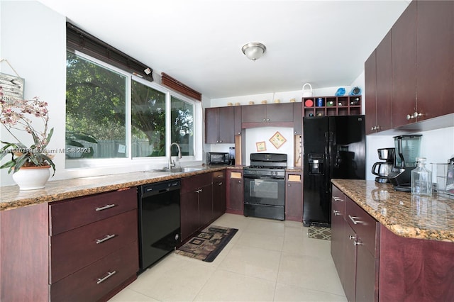 kitchen with sink, light stone counters, plenty of natural light, and black appliances