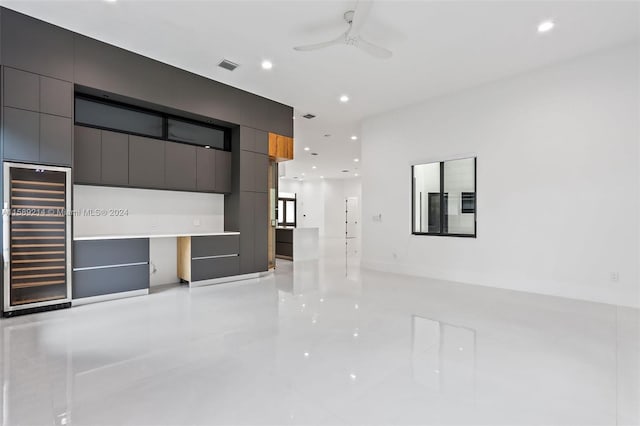 unfurnished living room featuring wine cooler and ceiling fan