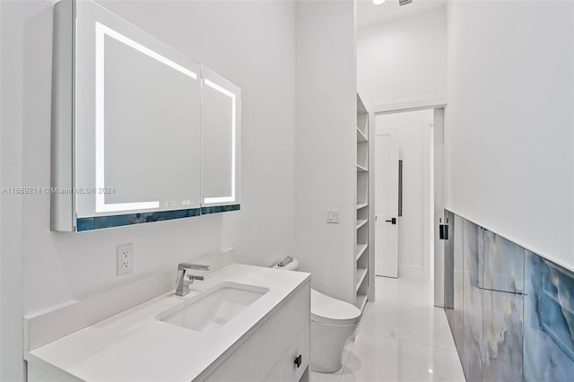 bathroom featuring tile patterned floors, vanity, and toilet