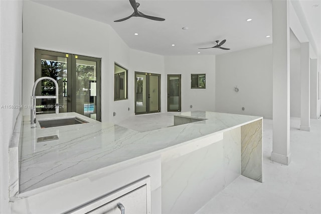 kitchen featuring sink, light stone countertops, french doors, and ceiling fan