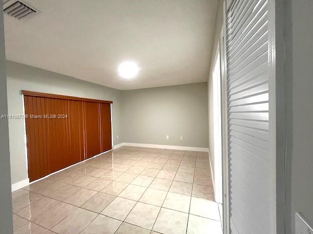 unfurnished bedroom with a closet and light tile flooring