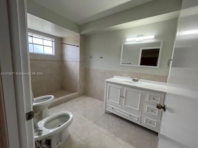 bathroom featuring toilet, a wainscoted wall, tile patterned floors, a tile shower, and tile walls