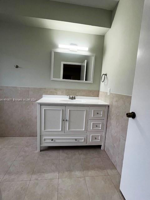 bathroom featuring tile walls, tile floors, and oversized vanity