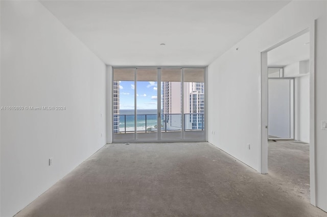 empty room featuring floor to ceiling windows and a water view