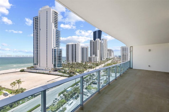 balcony featuring a view of the beach and a water view