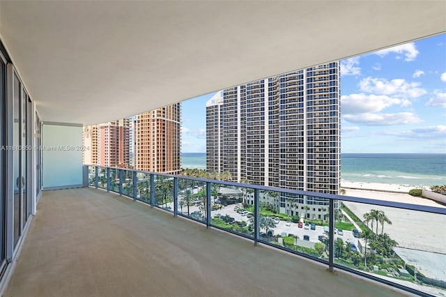 balcony featuring a view of the beach and a water view