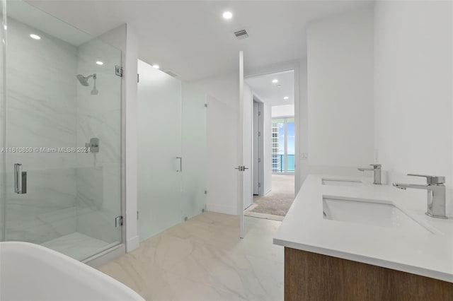 bathroom with a shower with shower door and vanity