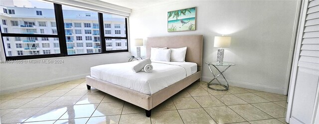 bedroom featuring ornamental molding, baseboards, and tile patterned floors