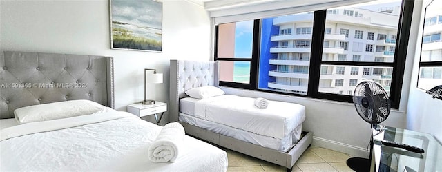 bedroom featuring multiple windows, tile patterned flooring, and baseboards