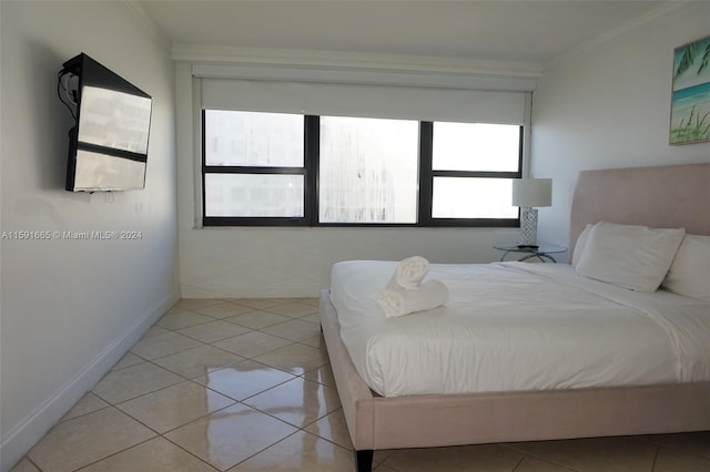 bedroom featuring crown molding, light tile patterned floors, and baseboards