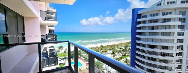 balcony featuring a view of the beach and a water view