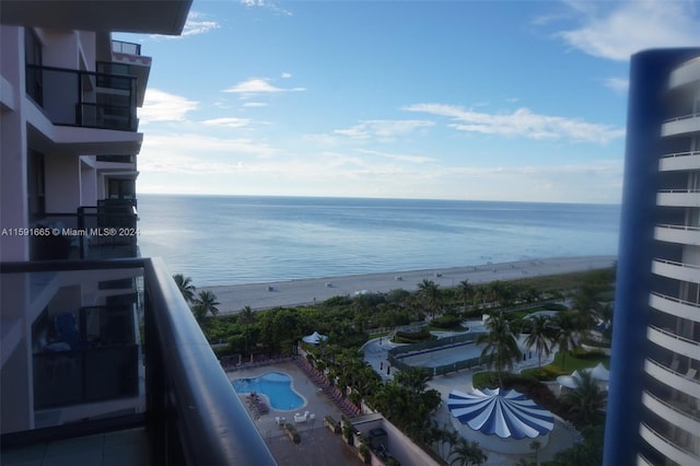 balcony featuring a view of the beach and a water view