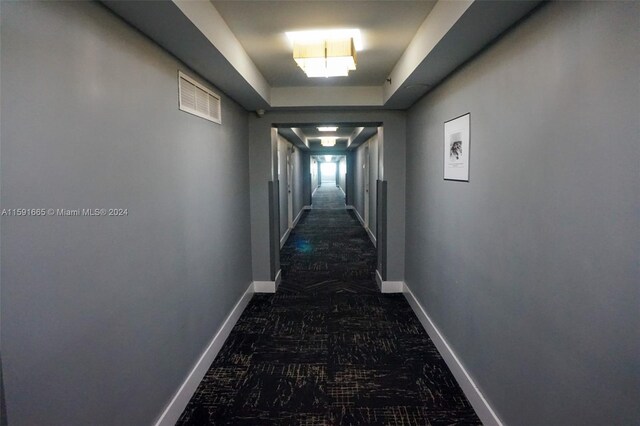 hallway with baseboards and visible vents
