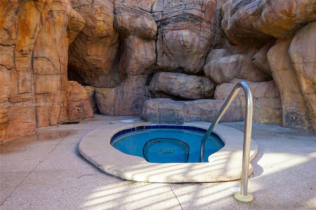 view of swimming pool featuring an in ground hot tub