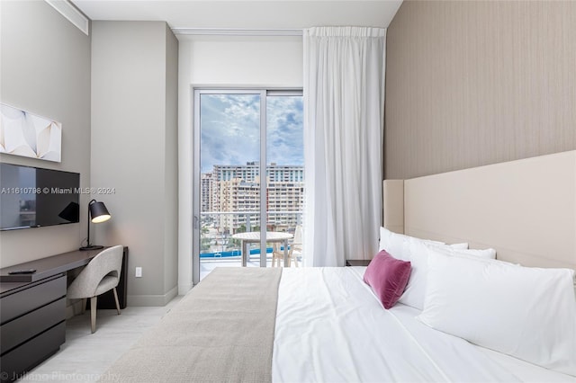 bedroom with light hardwood / wood-style flooring, access to exterior, and multiple windows