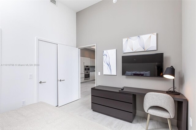 office featuring light carpet and a high ceiling