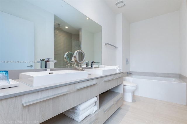 bathroom featuring a bathtub, double sink vanity, toilet, and tile floors