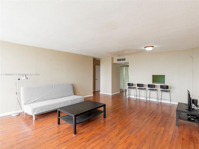 living room featuring a textured ceiling and hardwood / wood-style flooring