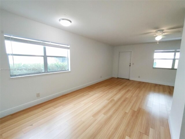 spare room with ceiling fan and light wood-type flooring